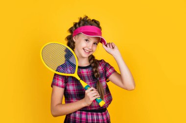 Spor şapkalı genç bir çocuk elinde tenis ya da badminton raketi tutuyordu.