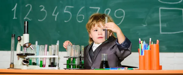 Παιδί με εργαστηριακή ποδιά μαθαίνει χημεία Μικρό παιδί μαθαίνει χημεία στο εργαστήριο του σχολείου. Μικρό αγόρι στο χημικό ντουλάπι. Εργαστήριο Χημείας. Πίσω στο σχολείο. πειραματίζονται με χημικά. Βελτίωση της σύγχρονης ιατρικής — Φωτογραφία Αρχείου