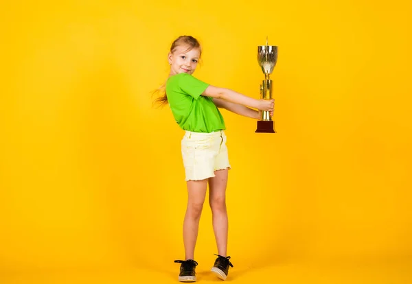 Grandi progressi. felice vincitore del concorso. la miglior ricompensa di sempre. bambino sorridente con coppa campionato. felicità infantile. bella ragazza adolescente in abbigliamento sportivo. campione di fitness per bambini. stile di vita sano — Foto Stock