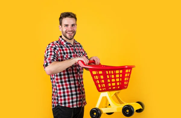 Moda tarzı olan şık bir adam. Kareli gömlek giyer, alışveriş arabası taşır. — Stok fotoğraf