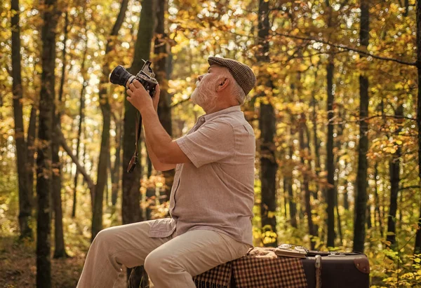 Shooting autumn session. Old man shoot in nature. Landscape and nature photo shooting. Using handheld shooting. Hobby and lifestyle. Shooting, filming and camerawork. Fall photoshoot