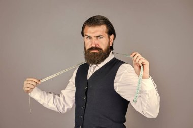 Detayları gözden geçiriyorum. Antika mobilyalarla muhteşem bir atölye. Model için özel dikim takım elbisenin portresi. İş gömleği mağazada mezura ile dikiliyordu. Beyaz gömlekli yakışıklı terzi çalışıyor.