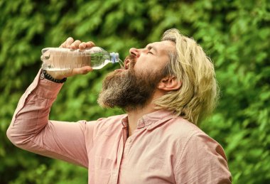 Yaz sıcağı. Temiz su içmek. Su dengesi. Sakallı turist su içen plastik şişe doğası. Susamış adam şişelenmiş su içiyor. Sağlıklı bir yaşam tarzı. Güvenlik ve sağlık