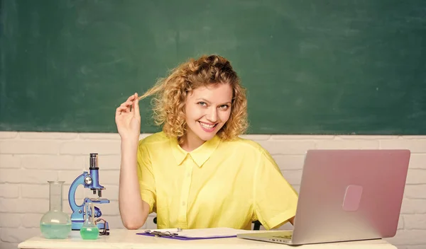 Fascinerende biologieles. Biologisch experiment. aantekeningen maken over chemische onderzoeksresultaten. Gelukkige student met microscoop en beker. meisje in klas laboratorium met computer — Stockfoto