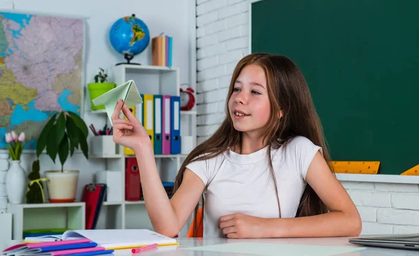 In een speelse bui. Het meisje studeert. terug naar school. tienermeisje werkt in een klaslokaal vlakbij schoolbord. Vrolijk kind leren vak. modern onderwijs. kennisdag. kind leerling zit aan tafel — Stockfoto