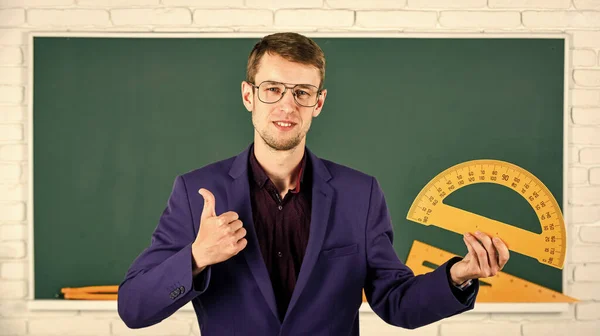 Teacher smart man at chalkboard young leader, education reforms concept