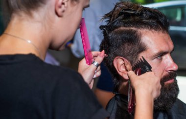Profesyonel berber ustası olan acımasız adam elektrikli tıraş makinesi kullanıyor. Hipster. Erkek berber bakımı. Kuaför salonundaki sakallı adam. Güzellik ve moda. Saç ve sakal. Taze funky güzellik