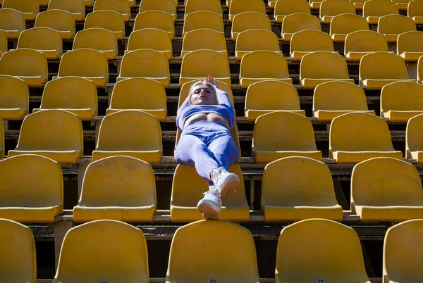 Athletic woman in sportswear relaxing on stadium. ready for warming up her muscles. female fitness coach. yoga and pilates. sport healthy lifestyle. sexy woman with tight buttocks. Sport is our life — Stock Photo, Image