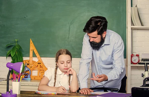 Pedagogo estricto. Habilidades pedagógicas. Haciendo papeleo de tareas caseras. Niño cansado estudio desmotivado aprender. Clases privadas. Educar en casa con padre. Profesora de escuela y colegiala. Hombre barbudo pedagogo —  Fotos de Stock