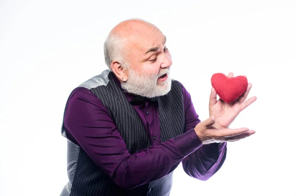 Sağlık hizmetleri. Kıdemli kel sakallı adam kırmızı kalbi tutuyor. Kalp krizini önlüyor. Kalp sorunu ve sağlık sigortası. Sevgililer günü kalbi olan olgun bir adam. Âşık ol. Kalp atışları ve tedavi — Stok fotoğraf