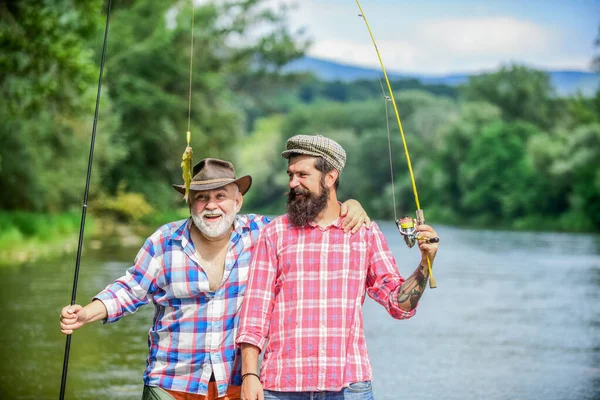 家族の時間だ。活動と趣味。淡水湖の池の川釣り。釣り竿を持つ漁師。髭を生やした男が魚を捕まえる。友人釣りの熟女.夏休みだ。幸せな陽気な人々 — ストック写真