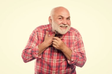 Hareketli stil. Berber dükkanı konsepti. Traş aksesuarları. Tıraş bıçağı alet çantası. Kes ve saç fırçala. Tıraşsız yaşlı adamın bıyığı ve sakalı var. Beyaz sakallı, olgun bir adam.