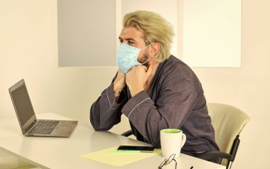 Sınırlı hastalık yayılıyor. Uzaktan iletişim. Sosyal uzaklık. Çevrimiçi çalışan serbest çalışan bir adam. Adam internette sörf yaparken maske takıyor. Uzaktan kumanda. Çevrimiçi topluluk. Coronavirus karantinası. Uzak görev