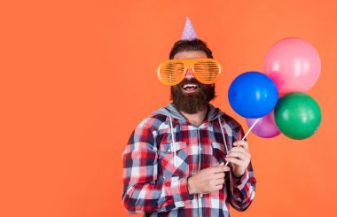 Havalı saç stili olan şık sakallı adam kareli gömlek giyer parti balonları, yıldönümü
