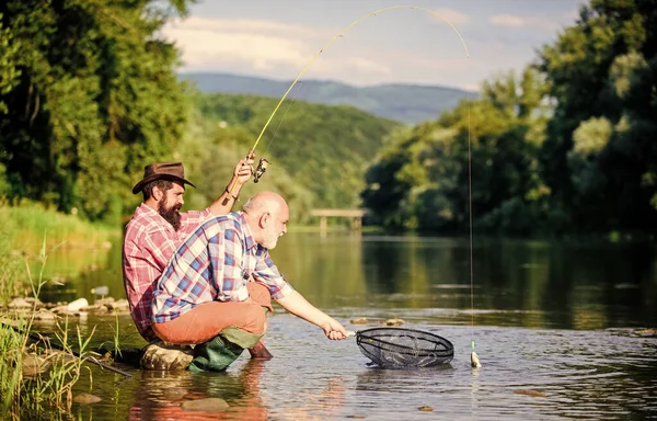 Herbst Angeln Spinnen. Zwei befreundete Männer angeln zusammen. Vater im Ruhestand und erwachsener bärtiger Sohn. glückliche Fischer-Freundschaft. Fliegenfischhobby der Männer. Fischerei im Ruhestand. Fangen und fischen — Stockfoto