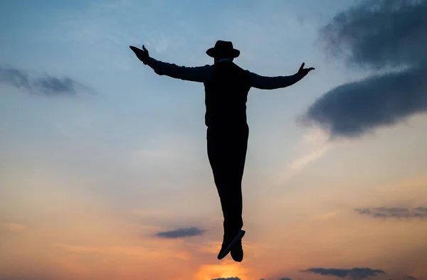 Silueta del hombre flotar en el cielo del amanecer con las manos levantadas, la libertad —  Fotos de Stock