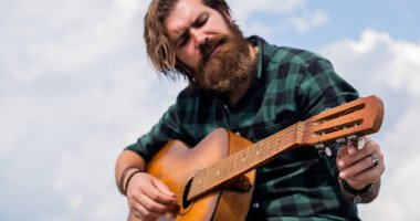 Alternatif taşlara. Olgun müzisyen ve şarkıcı. Sıradan stil gitarist. Modern görünümlü sakallı, akustik gitarlı hippi. Müzik konsepti. Bıyıklı vahşi yakışıklı adam gitar çalıyor.