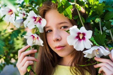 Mutlu çocukluk. Açık havada çiçek açan ağaçta neşeli sevimli bir çocuk. Tatil zamanı. Yaz modası ve güzellik. Amber çiçeği olan güzel bir genç kız. Çocuk bahar modası