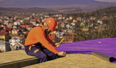 Roofer yeni çatı yapıyor. Çatı ustası yüzeyi. Profesyonel tamir çatısı. Düz çatı kurulumu. İnşaat binası. Su geçirmez çarşaf. Yüksek irtifa işe yarıyor. Isı yalıtımı