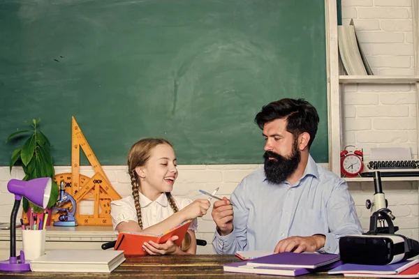 Domácí výuka s otcem. Najdi si kamaráda, který ti pomůže studovat. Soukromá lekce. Školní učitelka a školačka. Pedagogické dovednosti. Talentovaný pedagog. Pracujte společně, abyste dosáhli více. Muž vousatý pedagog — Stock fotografie