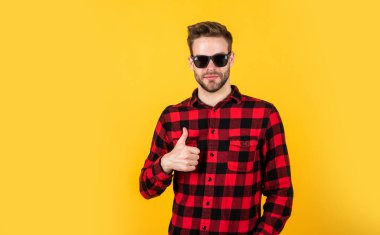Bu mükemmel. İyi bakımlı bir saç stili. Erkek güzellik ve moda. Sakallı adam için kareli gömlek. Tıraşsız, güneş gözlüklü yakışıklı adam. Kuaför konsepti. Genç ve kendinden emin