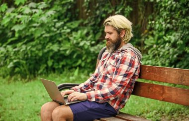 Çok çalışıyorum. İş adamı parkta defter kullanıyor. Ofisten kaçtı. Başarılı bir girişimci. Yetişkin bir adam dizüstü bilgisayarla parkta oturuyor ve e-postaları kontrol ediyor. Bilgisayar üzerinde çalışan serbest çalışan bir adam