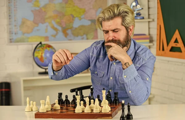 Figures on wooden chess board. Smart hipster man playing chess. Intellectual hobby. Thinking about next step. Chess is gymnasium of mind. Chess lesson. Strategy concept. School teacher. Board game
