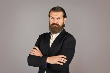 Pahalı takım elbiseli yakışıklı ve başarılı bir adam. O, beyaz gömlekli. Takım elbiseli başarılı bir adam. İş adamı takım elbise giyer. Resmi ofis hayatı. Ciddi sakallı adam. çapraz ellerle