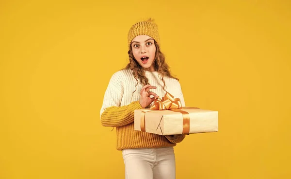 时尚的少女购物后的礼物。小孩抱着盒子黄色背景.收到包裹买完美的礼物。可爱的孩子喜欢购物。带着礼品包装的购物狂 — 图库照片
