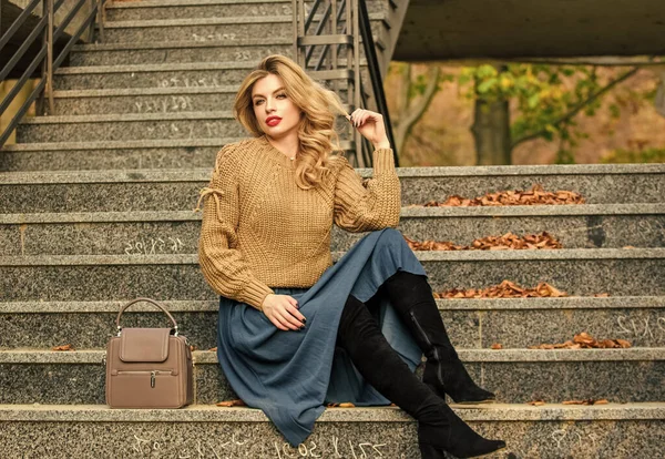 Layer oversize knit over girly skirt. Fall outfit formula. How to Style Sweater and Skirt Combo for Fall. Woman with gorgeous hairstyle sit on stairs outdoors. Fall fashion trend. Wearable trends — Stock Photo, Image