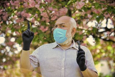 Enfeksiyonun yayılma riskini sınırla. Son sınıflar covid-19 hakkındaki yanlış bilgilere inanıyorlar. Dışarıda maskeli ve eldivenli kıdemli bir adam var. Enfeksiyon havada. Virüs enfeksiyonundan koru ve koru