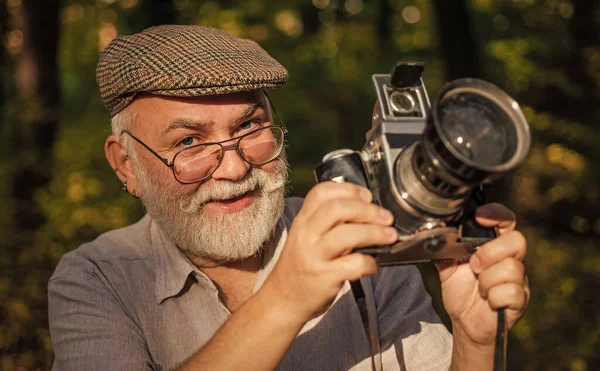 Він любить спостерігати за птахами. Пенсійне хобі. Досвідчений фотограф. Вінтажний фотоапарат. Старий стріляє природою. Професійний фотограф. Зробіть ідеальну рамку. Старий фотограф зйомок. Параметри вручну — стокове фото