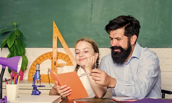 Schoolgirl holding lesson book. education child development. bearded man teacher with small girl in classroom. knowledge day. Home schooling. back to school. daughter study with father. Teachers day — Stock Photo, Image