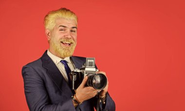 Şık ve eski moda. Elle ayarlar. Sarışın sakallı ve bıyıklı bir fotoğrafçı. İçerik yaratan. Sakallı hippi fotoğrafçı. Fotoğrafçı retro kamerayı beklesin. Vintage değerleri uzmanı
