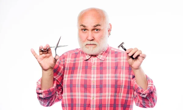 Cabelo facial de barba cortada. Cortar ou barbear. Escolha o comprimento perfeito e a forma da barba. A aparar barba e bigode. Serviço de arrumação. homem maduro barbeiro segurar tesoura e lâmina de barbear no fundo branco — Fotografia de Stock