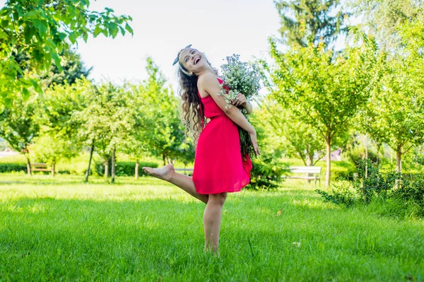 Happy kid girl harvesting organic chamomile flowers Stock Photo