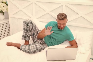 - Merhaba. Adam yatakta bilgisayar kullanıyor. İletişim ve insan konsepti. Çevik iş. Sabah titreşimleri. Adam dizüstü bilgisayarda çalışıyor. Online kurslar evde eğitim. İpuçlarını kilitle. Bir şeyler alıp internetten alışveriş yapmak.