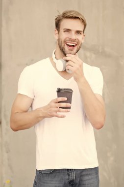 Enerji ve iyimserlik. Mutlu adam sıcak bardağı dışarıda tutuyor. Çay ya da kahvenin tadını çıkarıyorum. Kafein ve enerji molası veriyoruz. Lezzetli enerji içeceği. Sabahları enerji arttırıyorum. Moda müzik aksesuarı