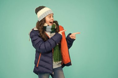 Öylece geçip gitme. Mutlu kız bir şeyi işaret ediyor. Küçük çocuk ürünü sunuyor. Ürün tanıtımı. Terfi ve pazarlama. Ürün satışı. Kış indirimi. Ürün reklamı, kopyalama alanı