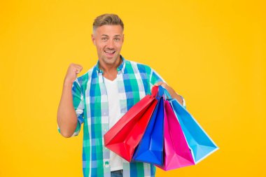 Kaliteli hizmet. Paketlerle alışveriş yapan erkek. Tatil için hazırlanın. Noel satışları ve indirimler. Doğum günü hediyesi paketleri. Alışverişkolik. Başarılı mutlu adam ağır alışveriş torbaları taşıyor. Kara Cuma