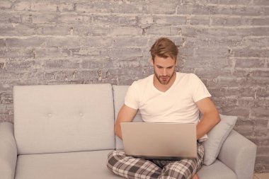 Online kurslar evde eğitim. İpuçlarını kilitle. Bir şeyler alıp internetten alışveriş yapmak. Adam kanepede bilgisayar kullanıyor. İletişim ve insan konsepti. Çevik iş. Sabah titreşimleri. Adam dizüstü bilgisayarda çalışıyor