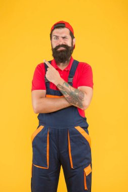 Tamirci üniformalı vahşi sakallı adam yetenekli bir tesisatçı ve reklamcı olarak çalışıyor.