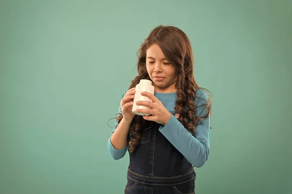 Cuidado de la salud infantil. Tome suplementos vitamínicos. La niña no quiere comer pastillas. Concepto de estilo de vida saludable. hermoso niño en los estantes de farmacia. suplementos dietéticos —  Fotos de Stock