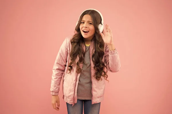 Déjame oírlo. La música da alegría. Niño feliz escuchar música de fondo rosa. La niña lleva auriculares tocando música. Nueva tecnología para niños. Diversión y entretenimiento. Estilo de vida moderno —  Fotos de Stock