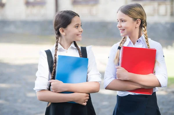 Crianças felizes em uniforme escolar segurar livros de estudo ao ar livre, biblioteca — Fotografia de Stock