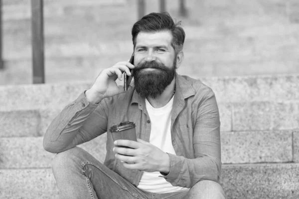 Koffie pauze. Persoonlijke communicatie. Ik bel een vriend. Aangenaam gesprek. Een echte connectie. Drink koffie terwijl je praat. Modern stadsleven. Een telefoongesprek met een baard. Mobiel gesprek — Stockfoto