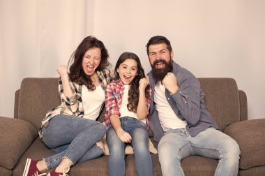 Evde kal. Aile kanepeye oturur. Mutlu baba, anne ve kız. Karantina ve tecrit kavramı. Gülümseyen aile. Birliktelik bizim gücümüz. Sonunda hafta sonu. Küçük kız ailesiyle rahatlıyor.