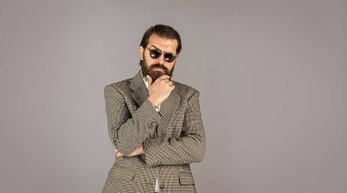 O, beyaz gömlek ve gözlük takıyor. Takım elbiseli başarılı bir adam. İş adamı takım elbise giyer. Resmi ofis hayatı. Ciddi sakallı adam. Pahalı takım elbiseli yakışıklı ve başarılı adam.