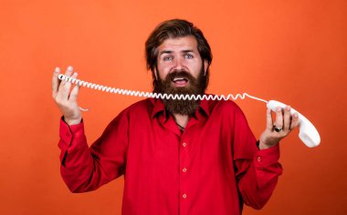 Olgun sakallı adam modaya uygun görünüyor. Retro telefonu tut, konuş.