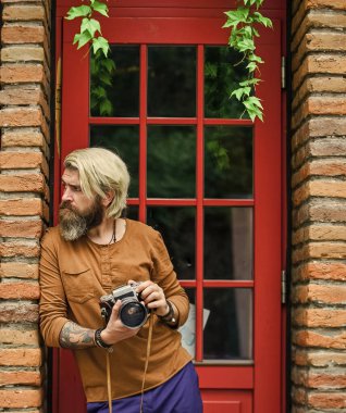 Profesyonel fotoğrafçı klasik kamera kullanır. Fotoğrafçılık işi. Yaratıcı kariyer. Yaratıcı fotoğrafçı kentsel arka plan İrlanda mimarisi tarzı. Fotoğraf çekimi. Retro kameralı zalim adam.